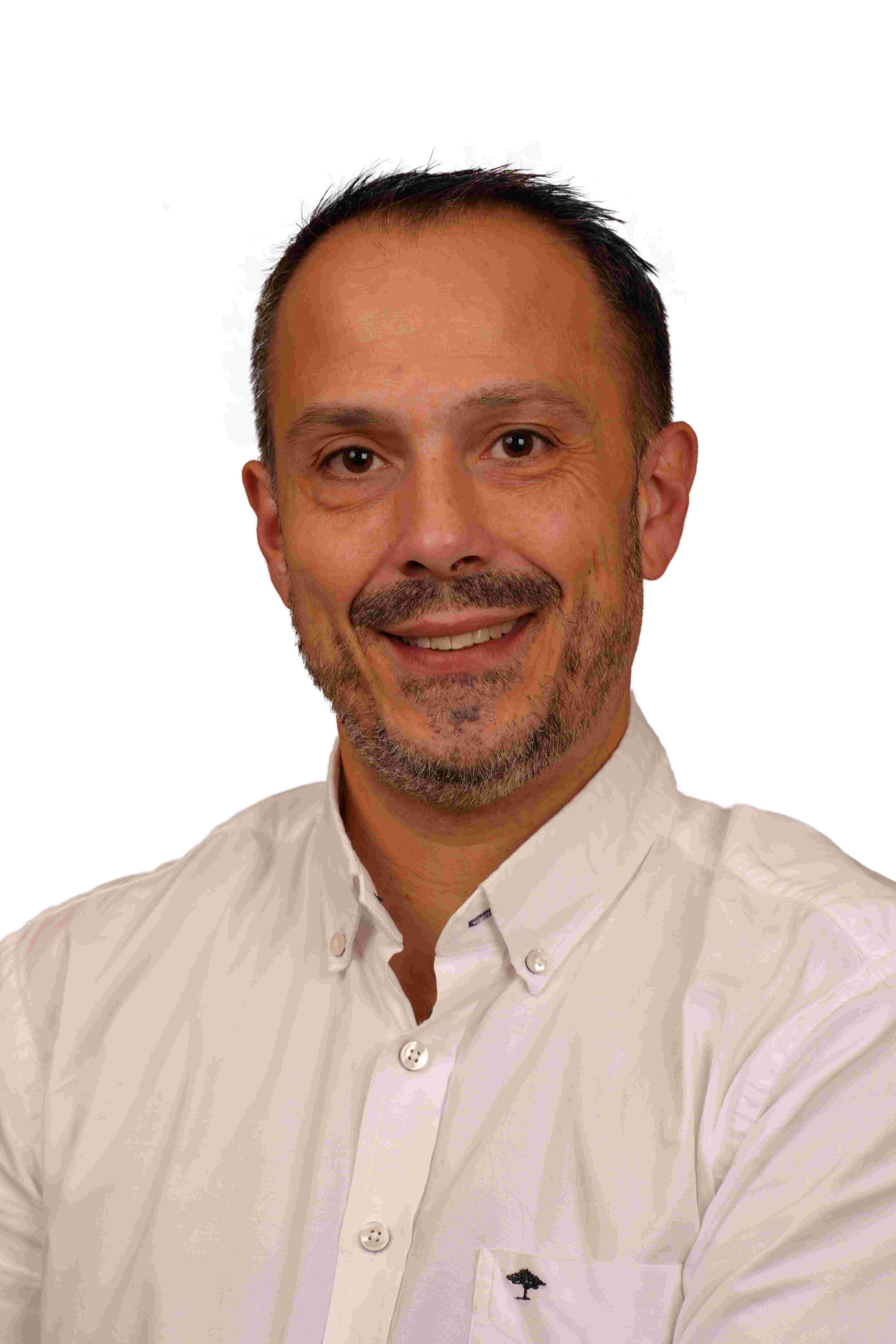 GV Compta - Giovanni Virzi, expert-comptable, posant de face dans un cadre professionnel. Il porte une tenue professionnelle et sourit légèrement, représentant son expertise en comptabilité et son approche personnalisée pour les clients.